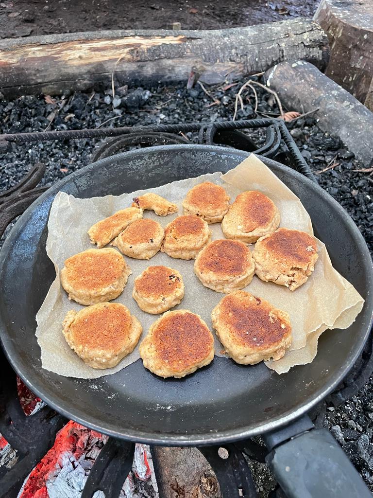 An image of the oat and raison cookies cooking over a campfire.